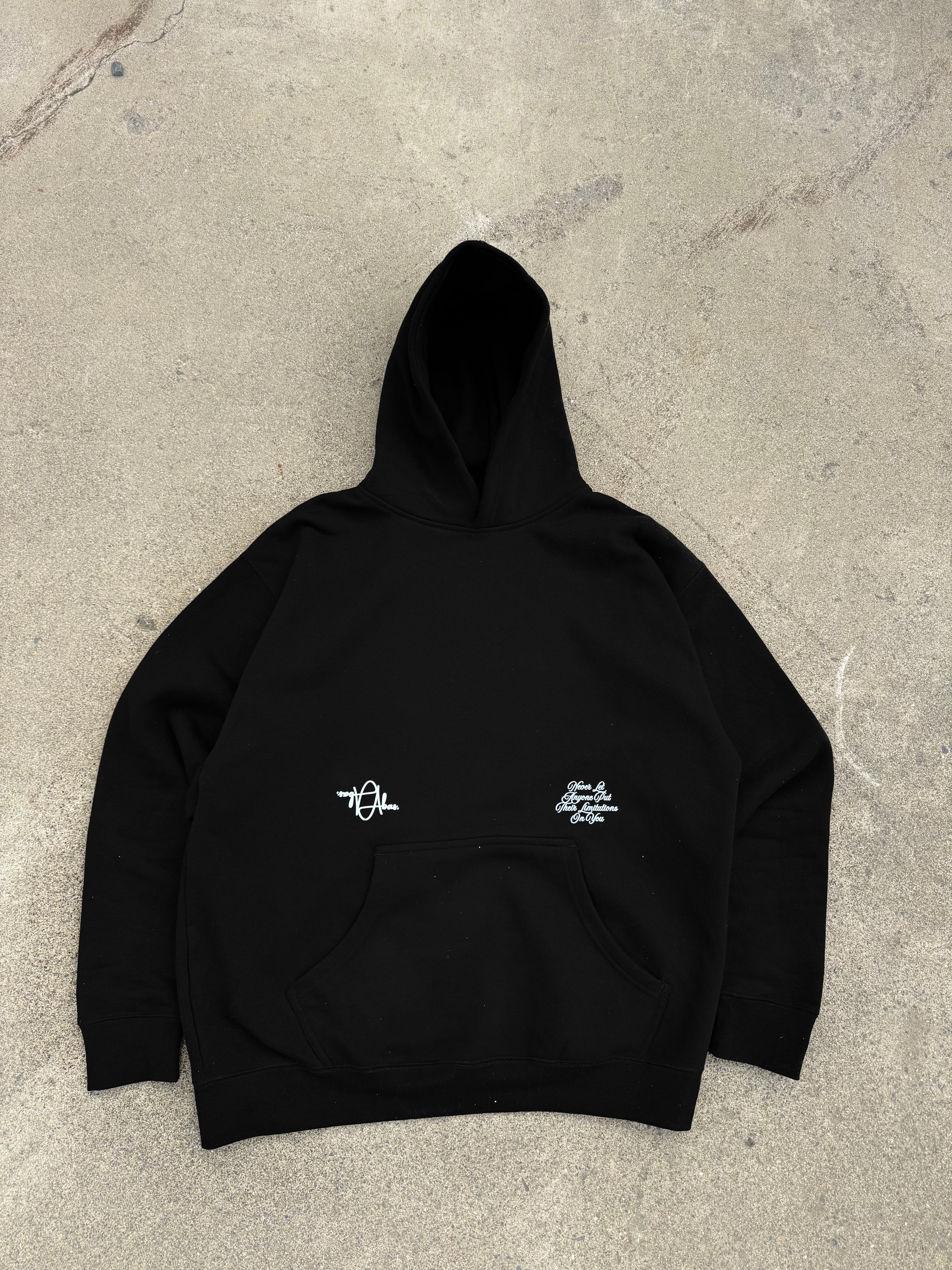 Black hoodie with white text on a concrete surface